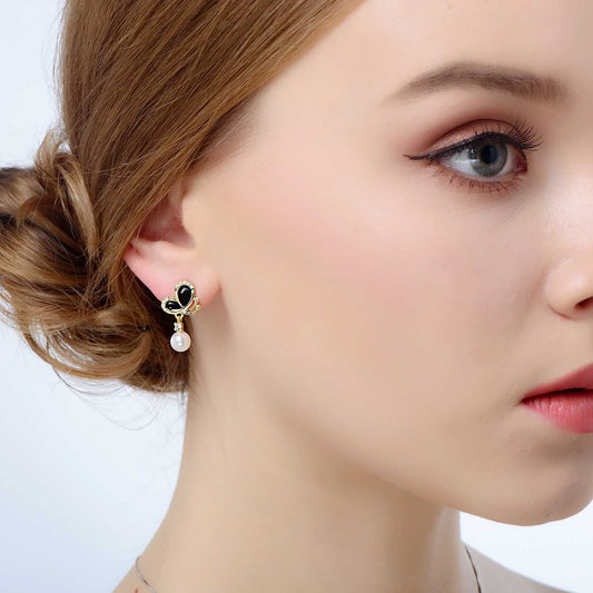 Model wearing black enamel butterfly pearl dangle earring in 18K gold-plated 925 silver, close view.