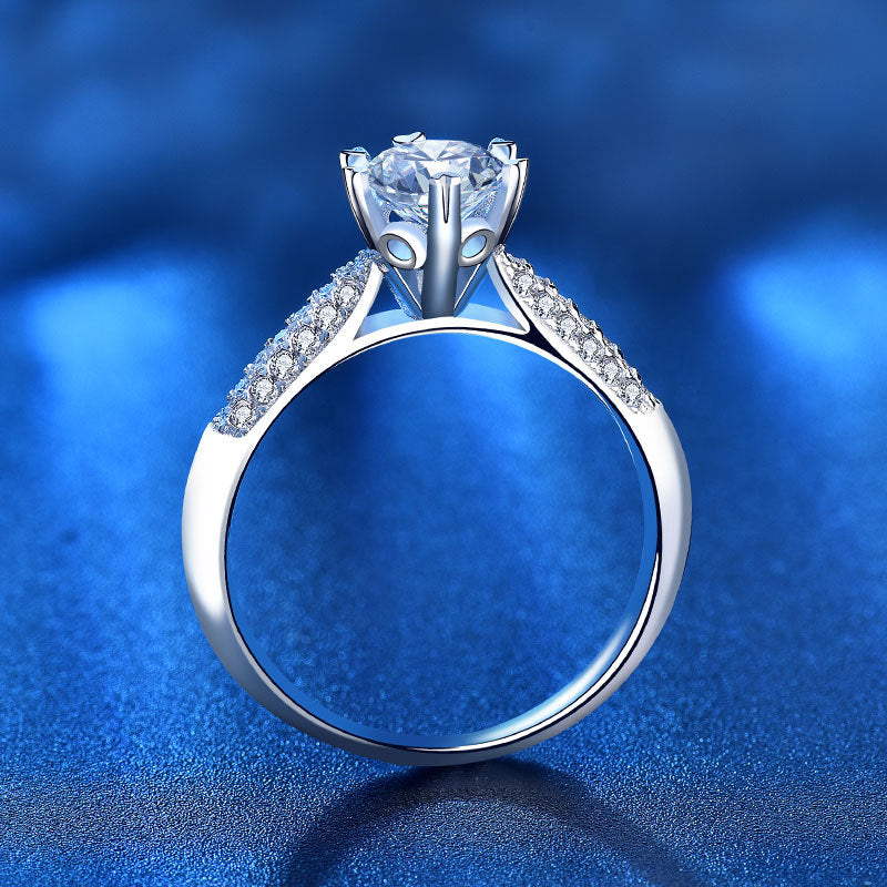 Side profile of six prong moissanite ring showing cathedral shoulders and basket setting in sterling silver.