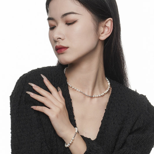 Model wearing baroque pearl bracelet and necklace in sterling silver, rhodium finish