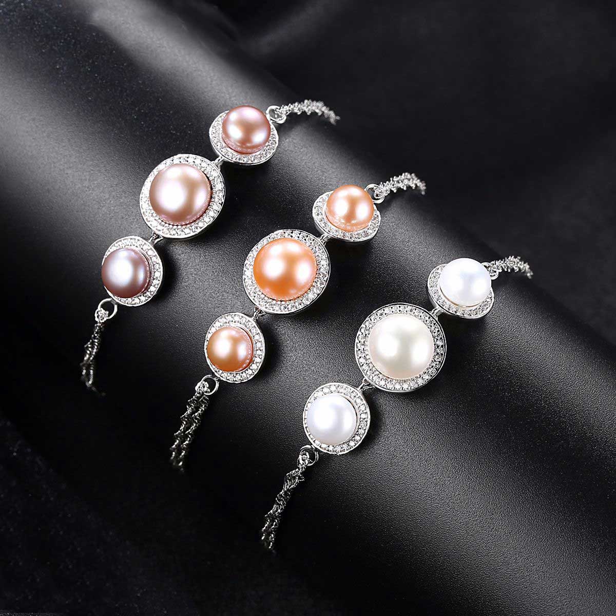Three pearl bracelets in pink, white, and purple tones on black background