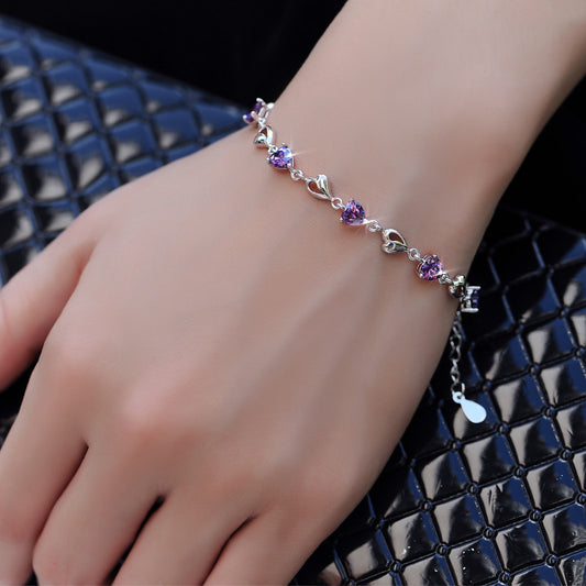 Model wearing purple heart-cut CZ sterling-silver bracelet with heart links