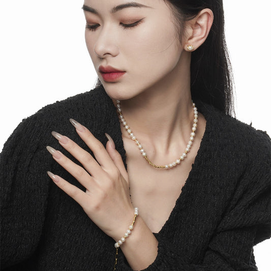 Model styling an irregular natural pearl necklace with 18K gold finish accents and matching bracelet