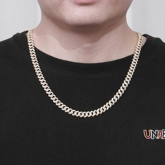 Close-up of man wearing gold iced CZ curb chain necklace over black shirt
