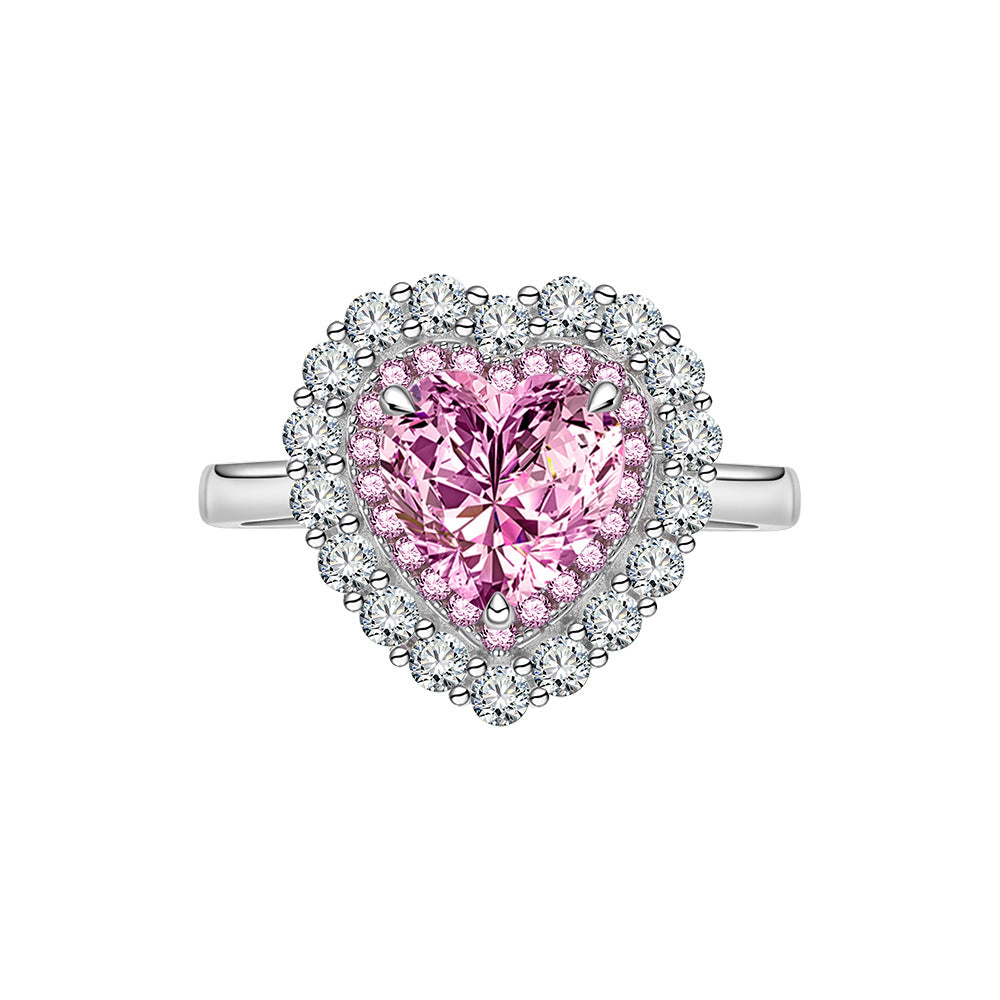 Front view of pink heart-cut CZ ring with double halo in 925 sterling silver on white background.
