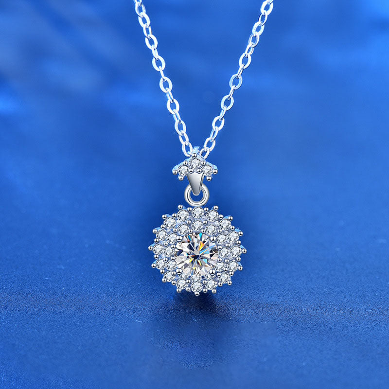 Close-up of 0.5 ct moissanite sunshine halo pendant necklace in 925 sterling silver on blue background.