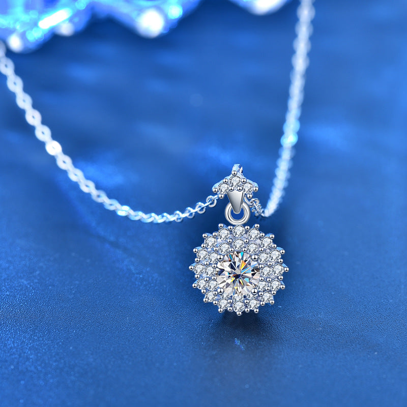 Angled view of sterling silver moissanite sunshine pendant with CZ halo, chain softly draped.