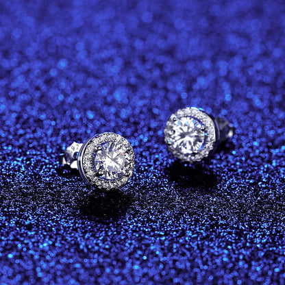 Blue background angled view of round halo moissanite studs showing raised halo setting.