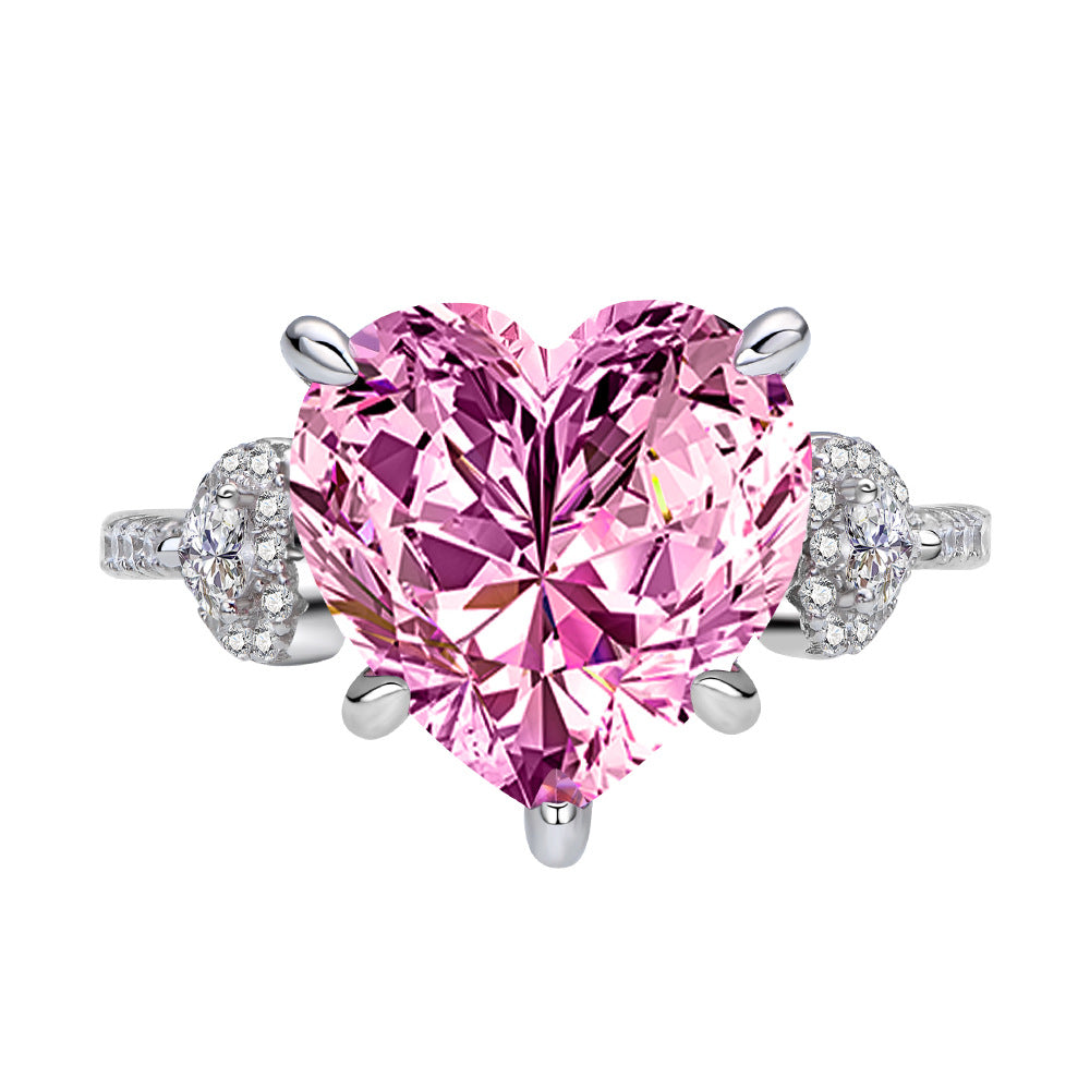 Close-up pink 12mm heart-cut CZ ring in rhodium-plated 925 silver with micro-set side accents.