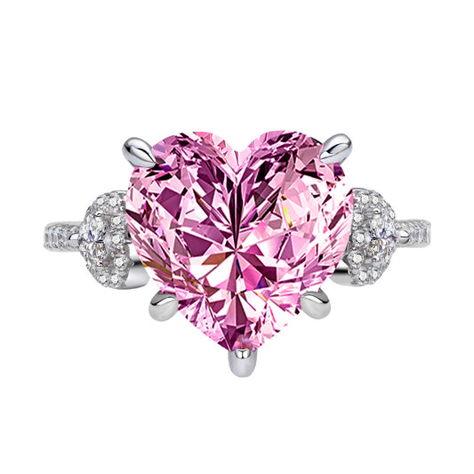 Close-up pink 12mm heart-cut CZ ring in rhodium-plated 925 silver with micro-set side accents.