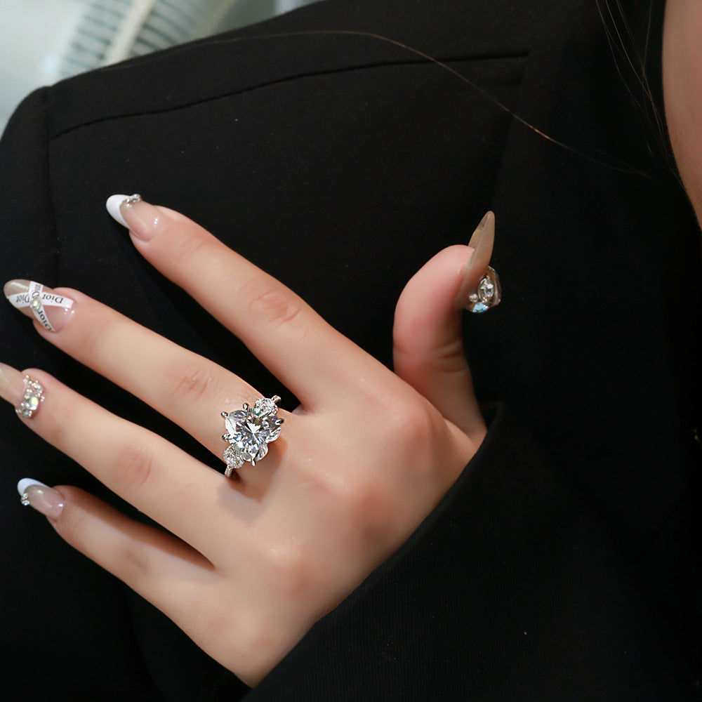 Model wearing white 12mm heart-cut CZ ring in rhodium-plated 925 silver with micro-set accents on the band.