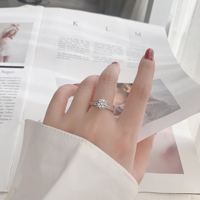 Lifestyle photo of woman wearing 1 ct moissanite blossom crown ring on ring finger.