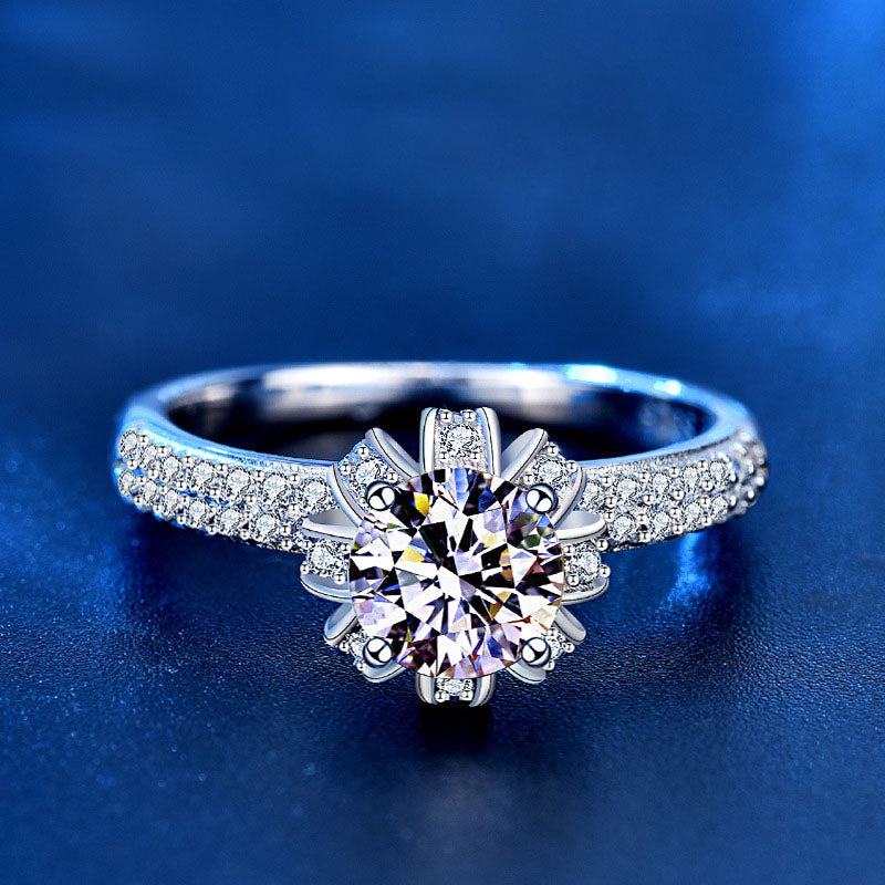 Front close-up of 1 ct round moissanite in blossom crown setting with CZ-pavé band.