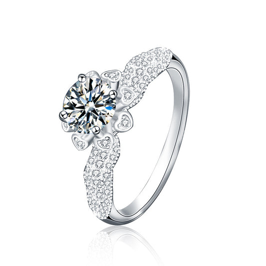 Studio shot of 1 ct moissanite floral halo ring in 925 sterling silver with heart halo and CZ pavé band.