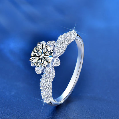 Angled view of 1 ct moissanite floral halo ring showing heart-petal halo and CZ pavé band in sterling silver.