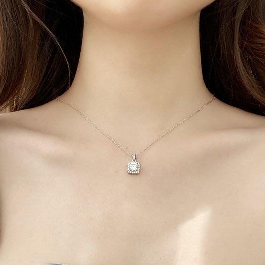 Model wearing sterling silver moissanite square halo pendant necklace on a short chain.