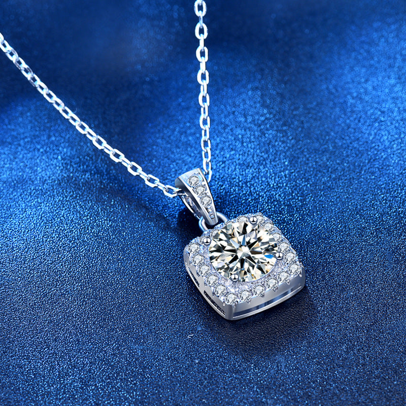 Angled view of square halo moissanite pendant with pavé CZ border and silver chain.