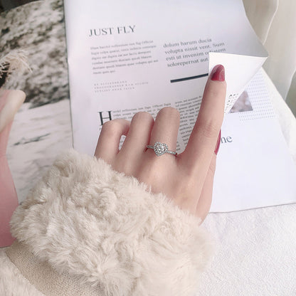 Heart halo moissanite ring in sterling silver worn on hand, delicate pavé band.