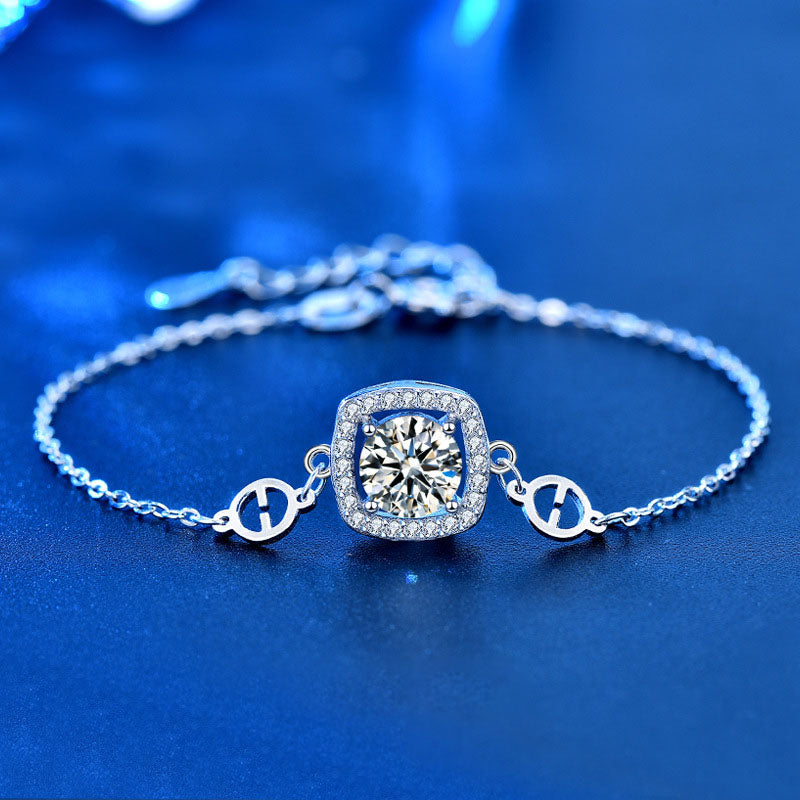 Close-up adjustable cushion halo moissanite bracelet in 925 sterling silver on a blue background.