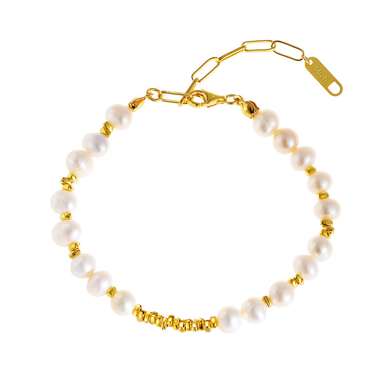 Studio image of adjustable baroque pearl bracelet in gold finish on white background