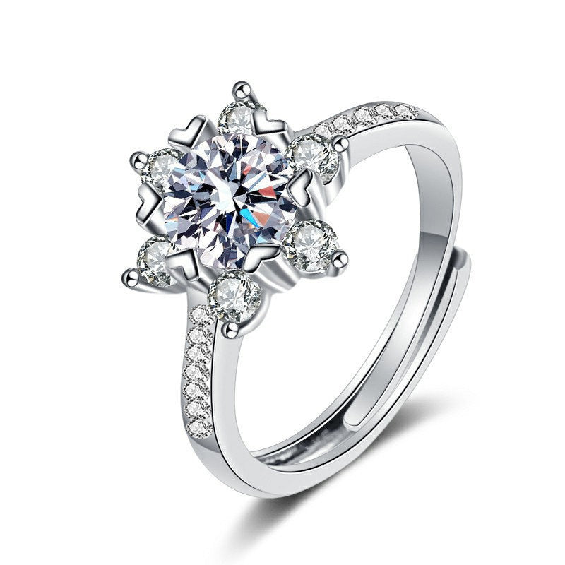 Sterling silver snowflake moissanite ring with pavé shoulders, isolated on white.