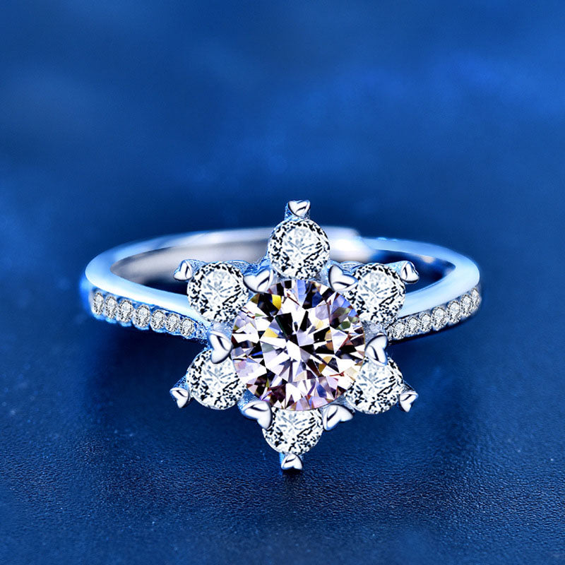 Close-up of snowflake moissanite ring in sterling silver with CZ accents on blue background.