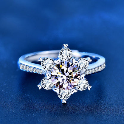 Close-up of snowflake moissanite ring in sterling silver with CZ accents on blue background.