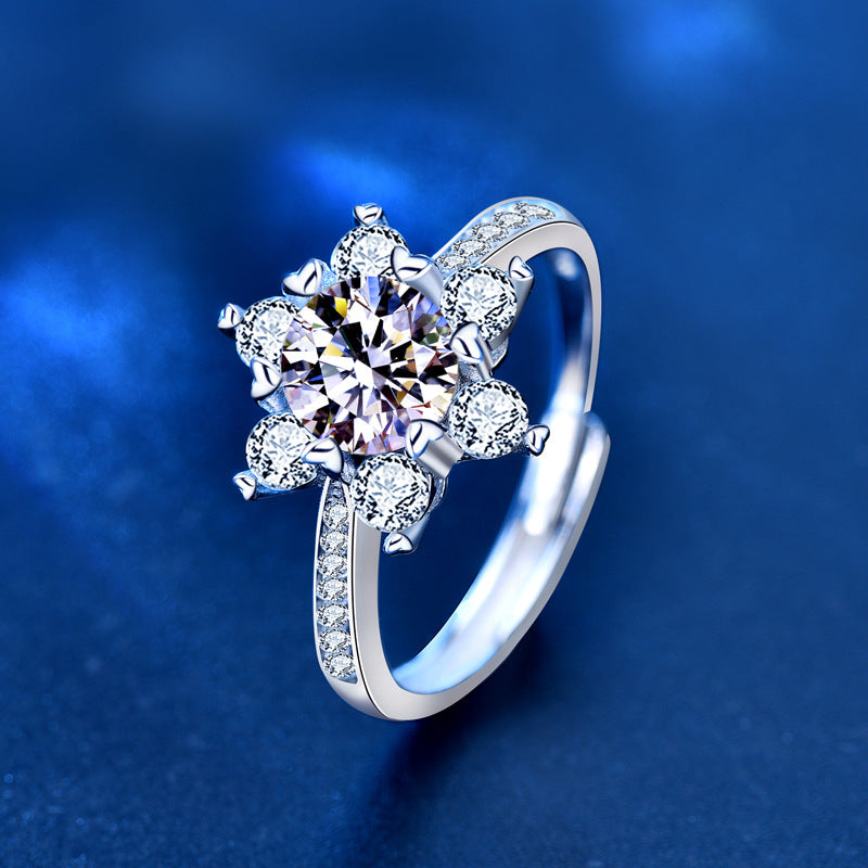 Angled view of adjustable sterling silver snowflake moissanite ring with pavé band.