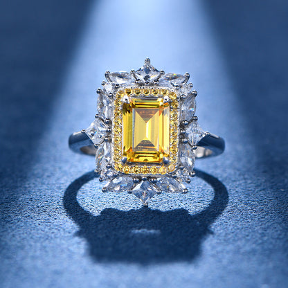 Close-up of yellow baguette-cut CZ halo flower ring in sterling silver on a blue backdrop.