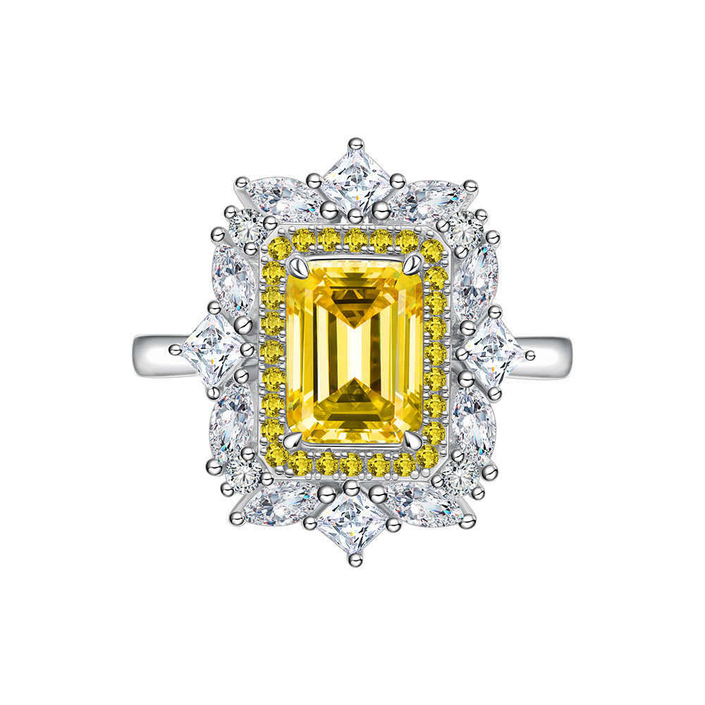 Studio shot of yellow baguette-cut CZ halo flower ring on white background.