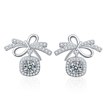 Packshot on white: bow stud earrings in rhodium-plated 925 silver with 0.5-carat moissanite and AAA CZ halos.