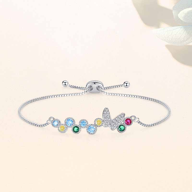 Sterling silver adjustable bolo bracelet with pavé butterfly and multicolor round CZ stones on soft background.