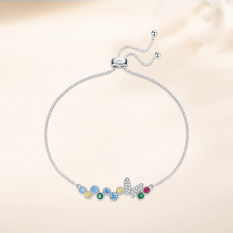 Adjustable 925 sterling silver bolo bracelet with pavé butterfly and multicolor CZ stones, full view on neutral background.