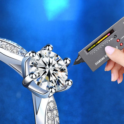 Close-up of 1 ct moissanite six-prong ring tested with a diamond tester; CZ accents visible