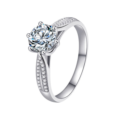 White background studio image of six-prong 1 ct moissanite ring in sterling silver with pavé CZ accents