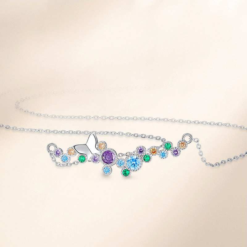 Flat-lay of sterling silver butterfly necklace with colorful cubic zirconia accents.