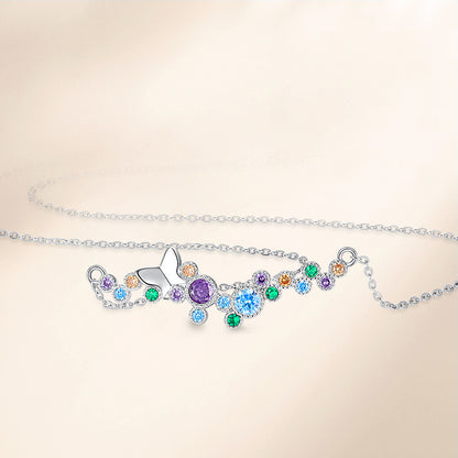 Flat-lay of sterling silver butterfly necklace with colorful cubic zirconia accents.