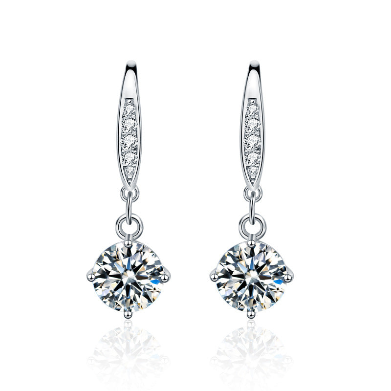 Studio image of sterling silver moissanite dangle earrings with CZ-pavé accents on ear wires