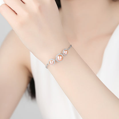 Model wearing pink pearl and CZ halo bracelet on wrist