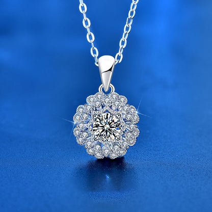 Front view of Moissanite flower pendant necklace on silver chain against blue background