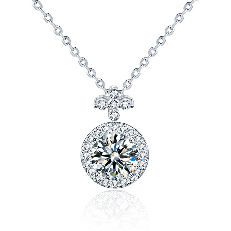 Studio product shot of moissanite halo pendant necklace with fleur-de-lis bail on a white background.