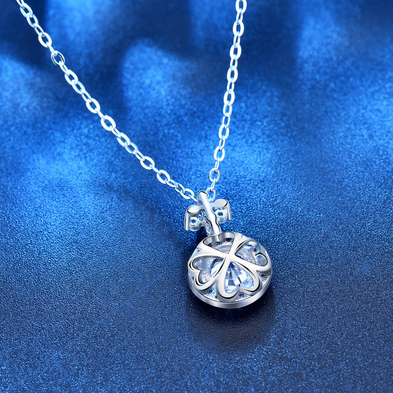 Back view showing openwork four-leaf-clover setting behind the round moissanite pendant.