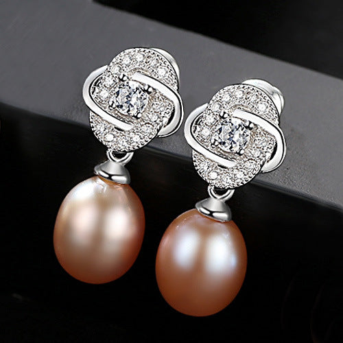 Pink freshwater pearl CZ dangle earrings in rhodium-plated sterling silver, angled view.