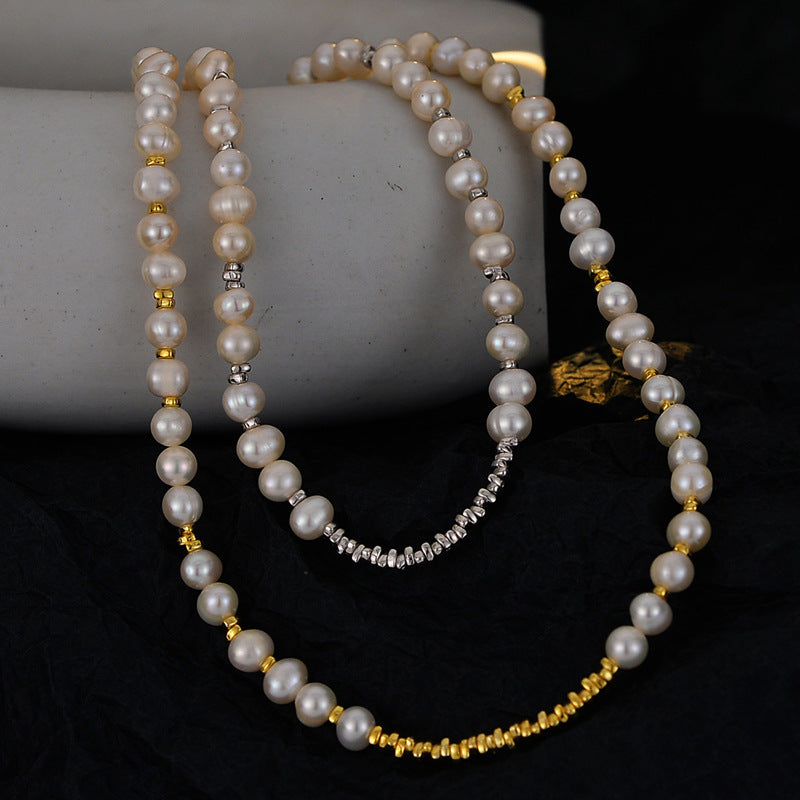 Irregular natural pearl necklaces with silver and 18K gold spacer beads draped over a stone prop