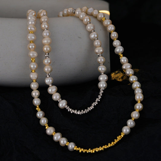 Irregular natural pearl necklaces with silver and 18K gold spacer beads draped over a stone prop