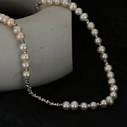 Detail view of irregular pearls and sterling-silver spacer beads on a dark background