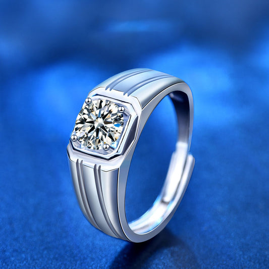 Angled view of men’s 1 ct moissanite signet ring in sterling silver with octagonal bezel and grooved shoulders on blue.
