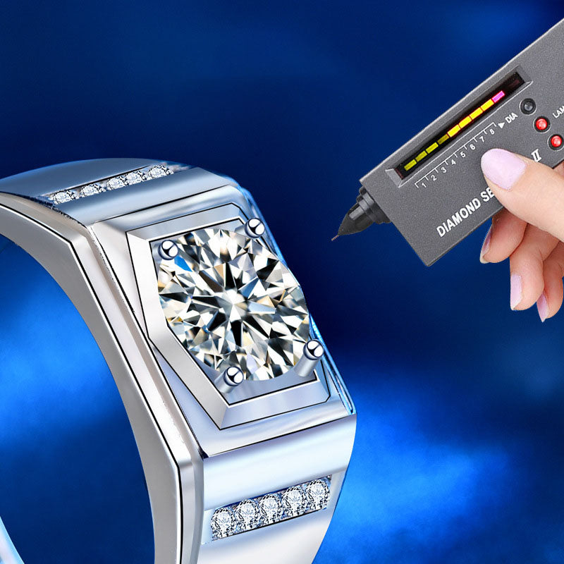 Close-up of ring center with diamond tester near round moissanite in a four-prong geometric setting.