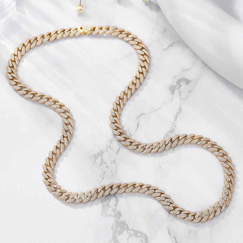 Gold iced CZ curb chain necklace arranged on marble background