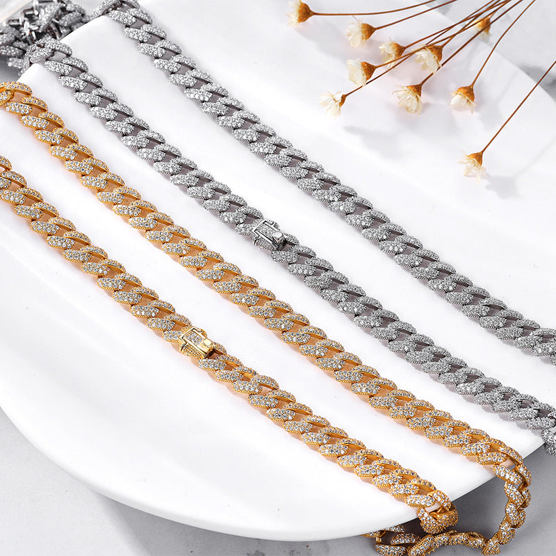 Silver and gold iced CZ curb chain necklaces side by side on white plate