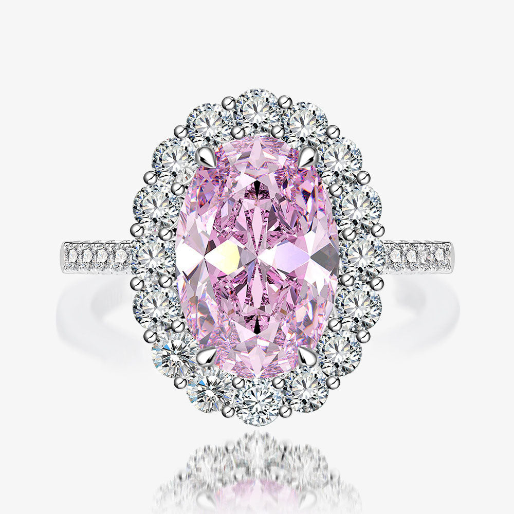 Close-up of pink oval halo CZ ring in rhodium-plated 925 sterling silver with pavé band.